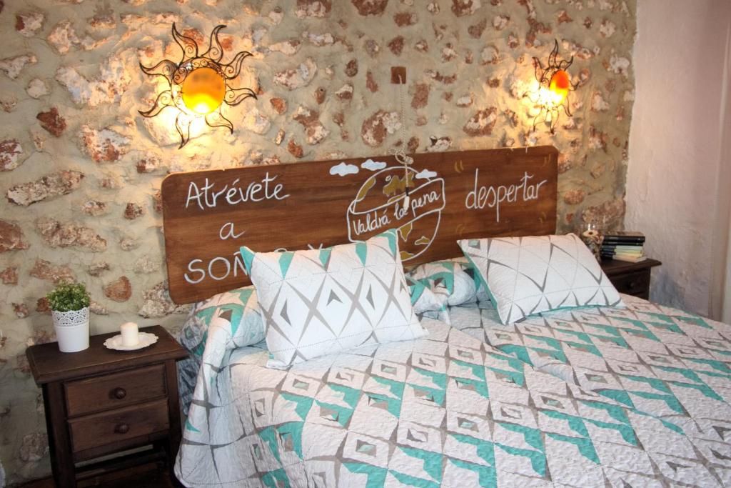 a bedroom with a bed with a wooden head board at La Carrihuela in Algodonales