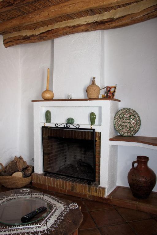 a living room with a brick fireplace with shelves at La Carrihuela in Algodonales