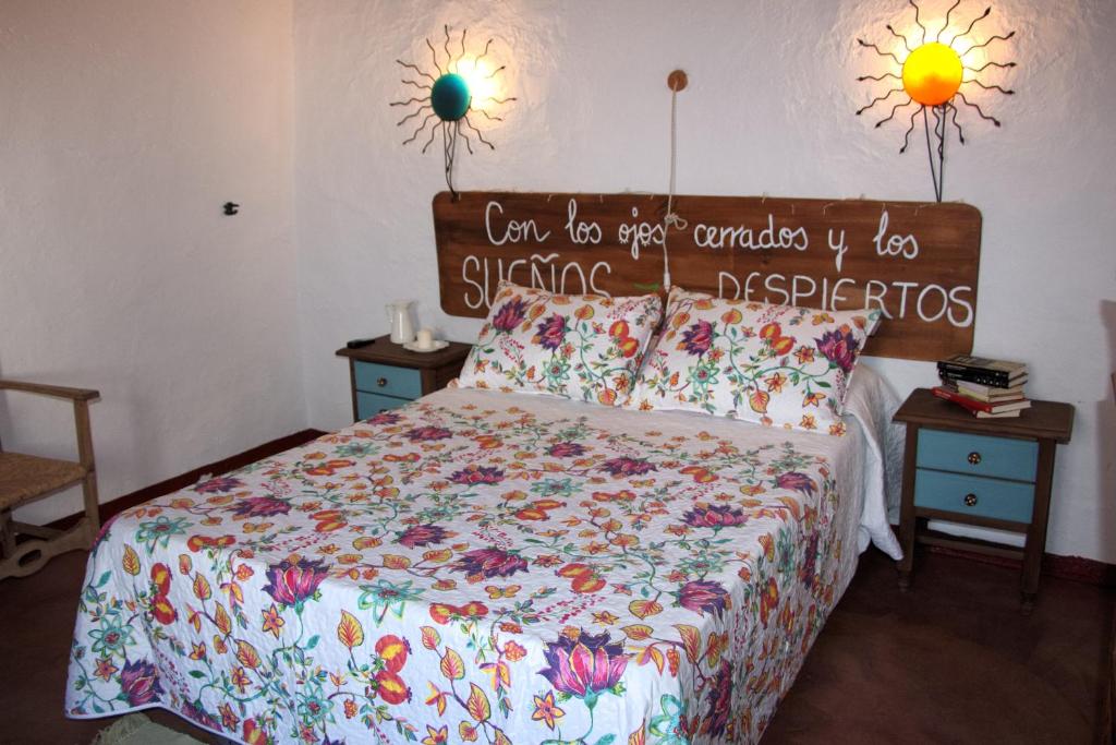 a bedroom with a bed with a comforter and two night stands at La Carrihuela in Algodonales