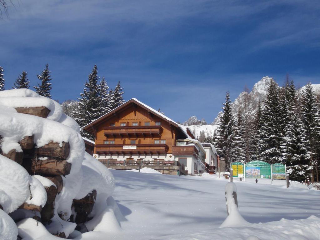 una cabaña de madera en la nieve con árboles nevados en Gasthof Edelbrunn, en Ramsau am Dachstein