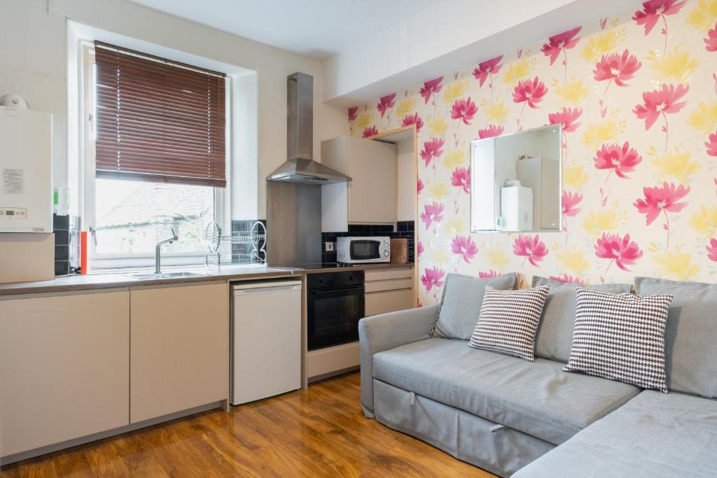 a living room with a couch and a kitchen at Fraser Apartment in Aberdeen