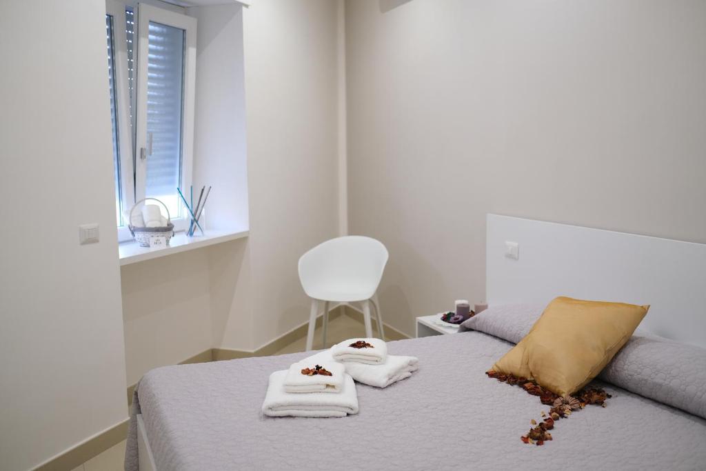 sypialnia z ręcznikami na łóżku z krzesłem w obiekcie Hoa Suites w mieście Aversa