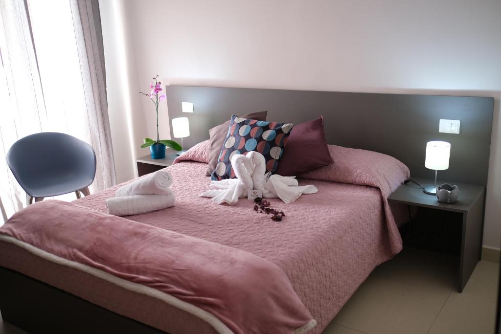 um quarto com uma cama rosa com um bicho de peluche em Hoa Suites em Aversa