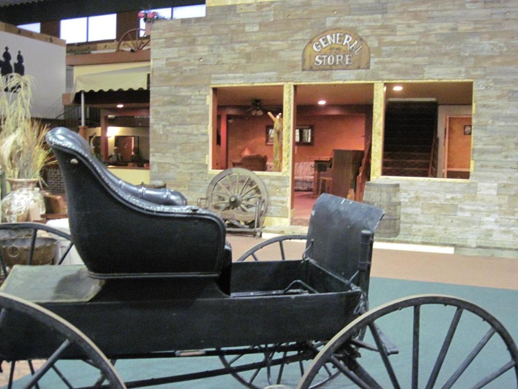 un carruaje tirado por caballos negros frente a una tienda en Dodge House Hotel en Dodge City