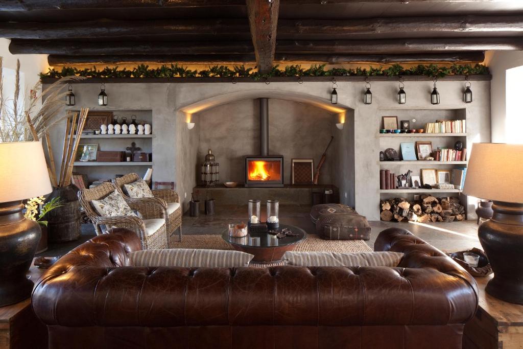 a living room with a leather couch and a fireplace at A Casa do Governador in Évora