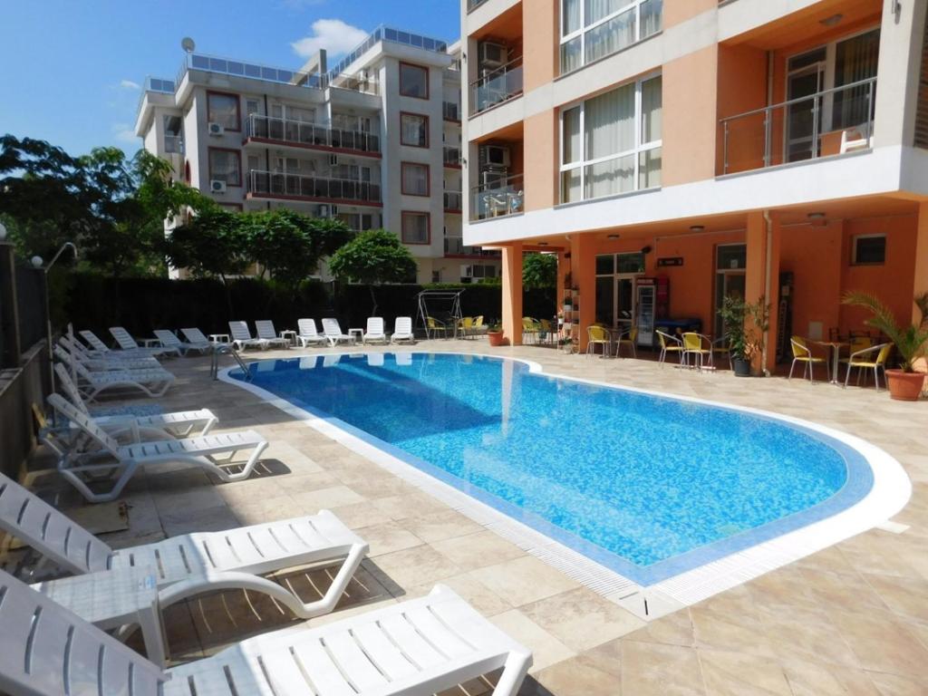 uma piscina com cadeiras e um edifício em Hotel Darius em Sunny Beach