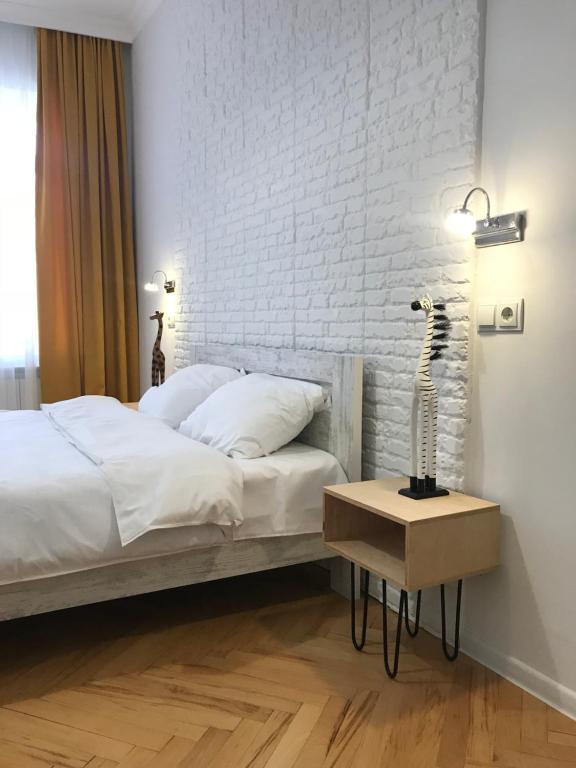 a bedroom with a bed and a white brick wall at Guest House Story in Tbilisi City