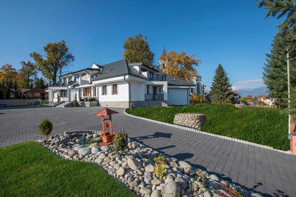 利普托斯基米庫拉斯的住宿－Villa Bellevue Wellness，一座带石头车道的大型白色房屋