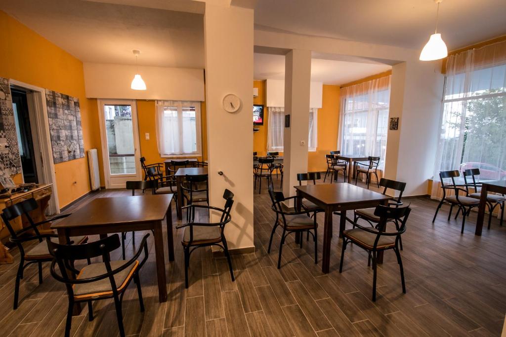a restaurant with tables and chairs in a room at The Holy Rock - Hostel at meteora in Kalabaka