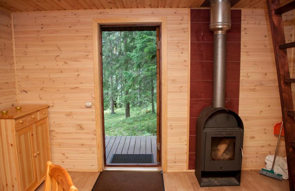 una camera con stufa a legna in una cabina di Kimalase Metsamaja a Misso