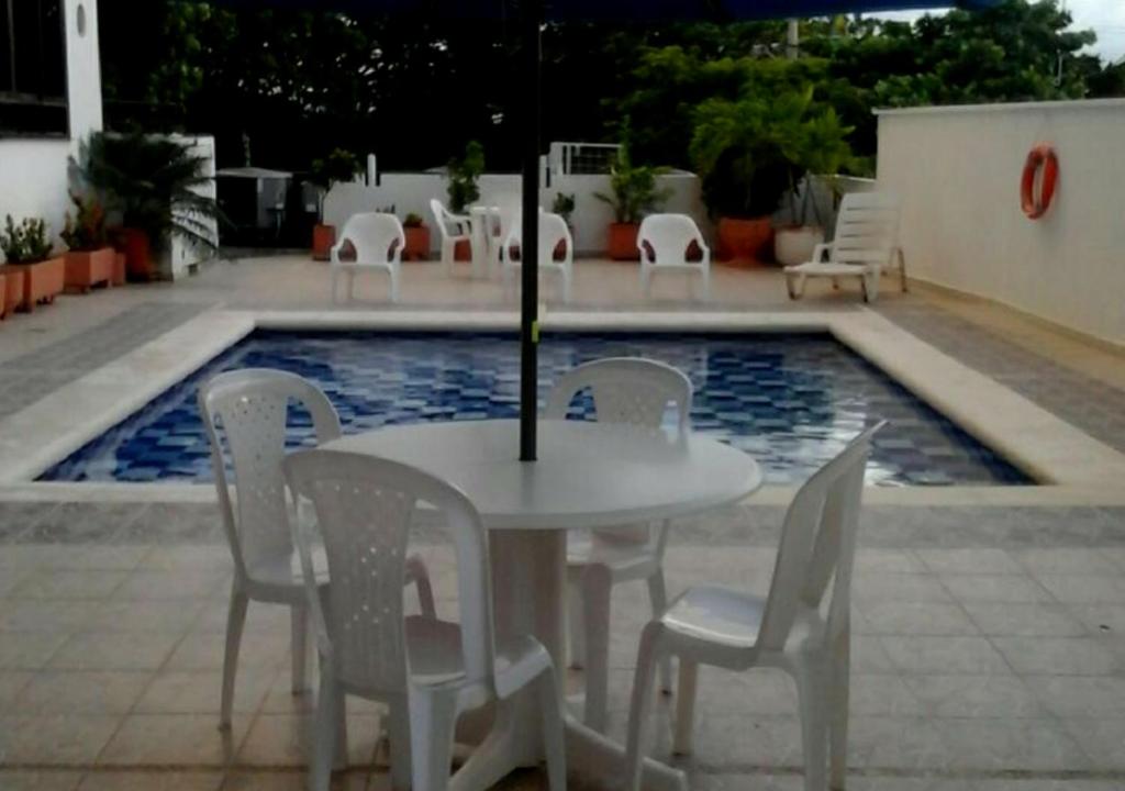 a white table and chairs next to a swimming pool at Apartamento para parejas frente a la playa San Andres in San Andrés