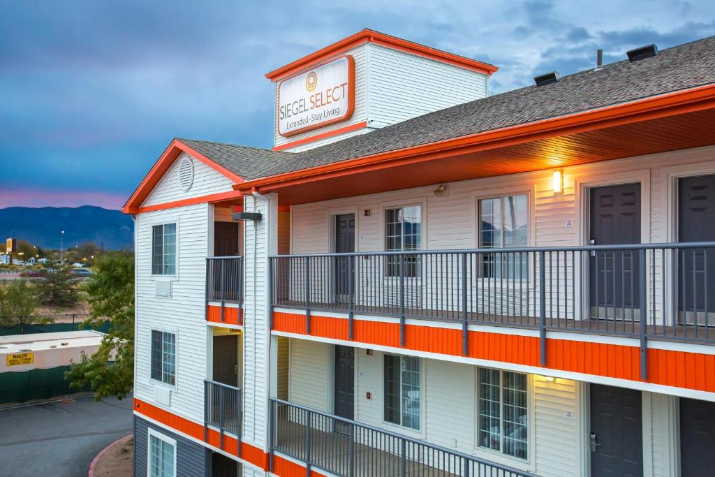 - un bâtiment blanc avec un balcon orange et blanc dans l'établissement Siegel Select Albuquerque 2, à Albuquerque