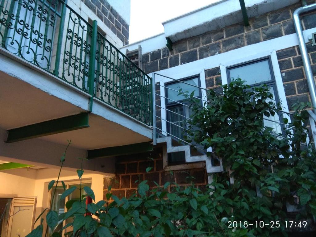 un edificio de apartamentos con balcón y un árbol en Berenice Winery Suites, en Tiberíades