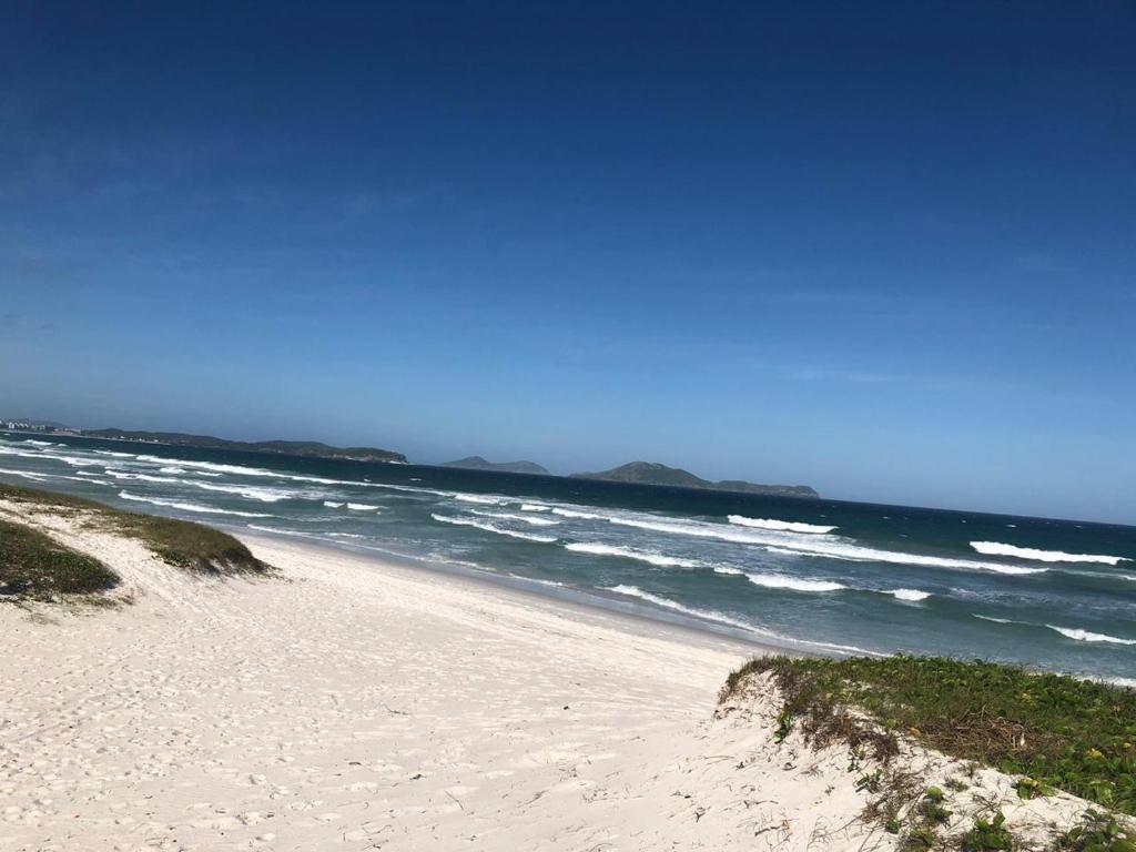 une plage de sable avec l'océan en arrière-plan dans l'établissement Casa da Praia das Dunas, à Cabo Frio