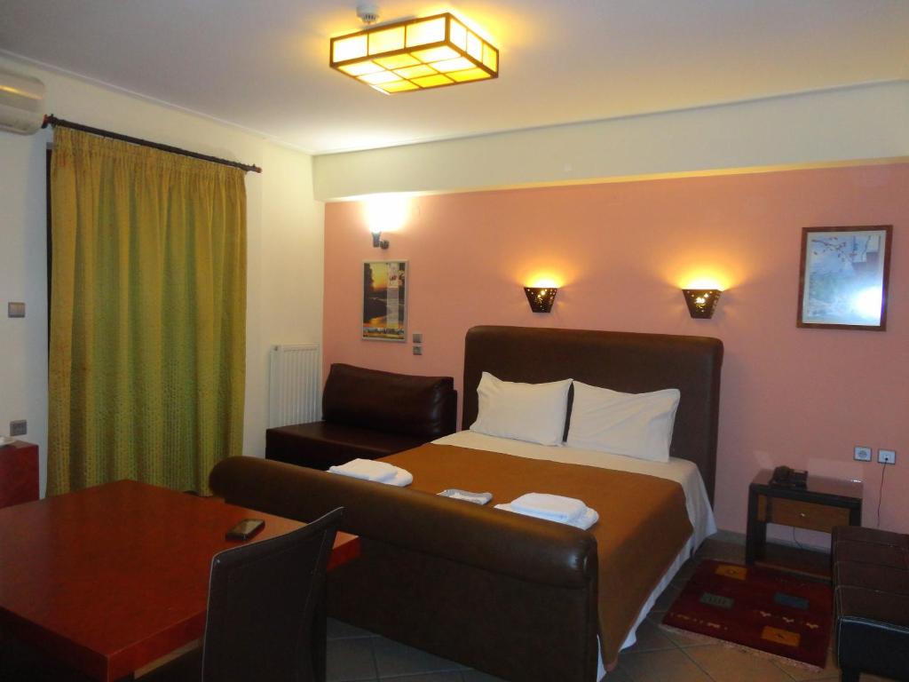 pokój hotelowy z łóżkiem, kanapą i stołem w obiekcie Lirio Guest House w mieście Makrakómi