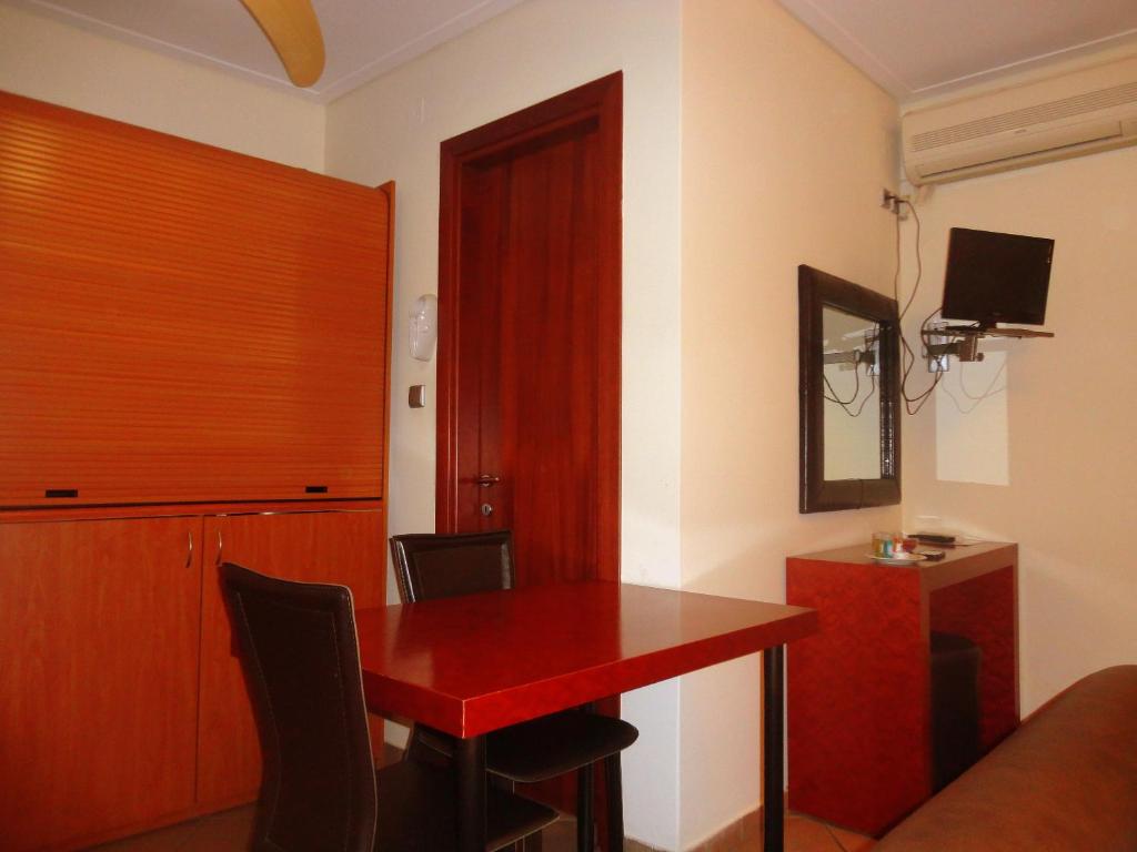 Pokój z czerwonym stołem i czerwonymi drzwiami w obiekcie Lirio Guest House w mieście Makrakómi