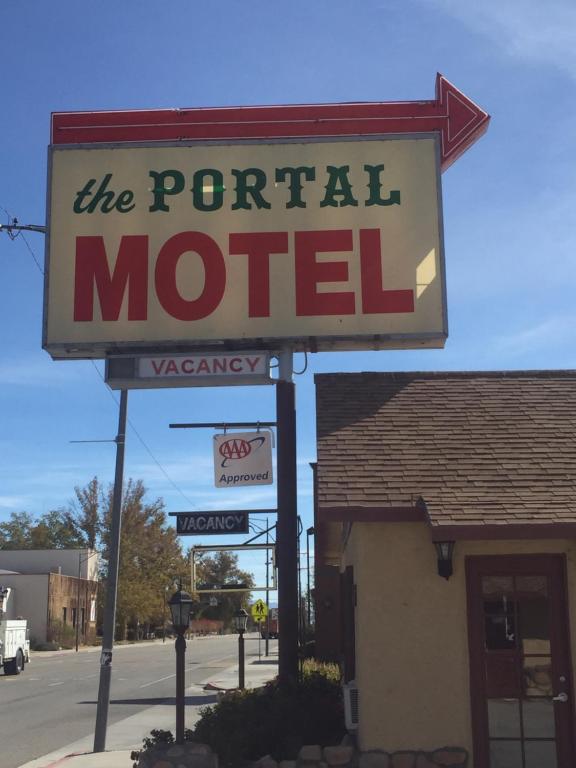 un cartello per un motel di fronte a un edificio di Portal Motel a Lone Pine