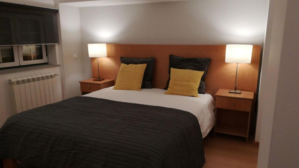 - une chambre avec un grand lit et des oreillers jaunes dans l'établissement Casa da Fonte Sagrada, à Loriga