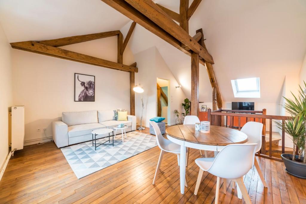 a living room with a table and a couch at Newcenter Duplex in Auxerre