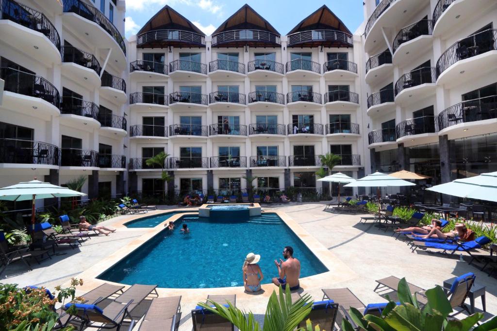 um hotel com piscina em frente a um edifício em PACIFIC SUITES Boutique Hotel and Bistro em Jacó