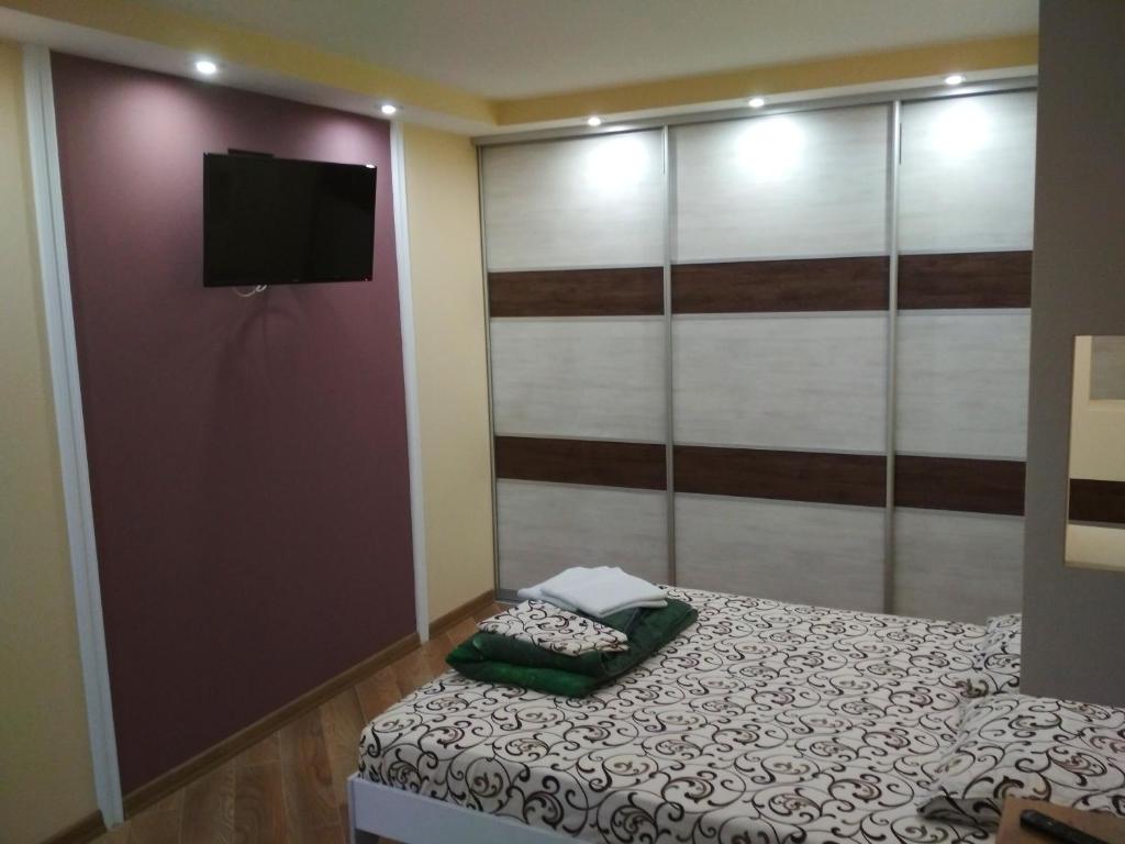a bedroom with a bed and a flat screen tv at Apartments in the Center Maidan in Rivne