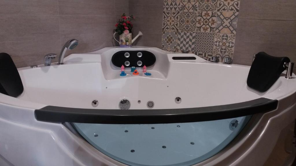 a white bath tub with a black rim and a sink at Lagar II con Jacuzzi in Curiel de Duero
