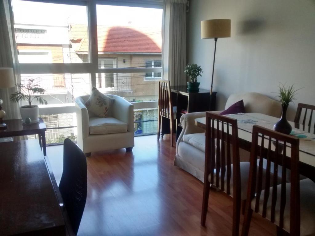 a living room with a table and chairs and a large window at Edificio San Diego in Mar del Plata