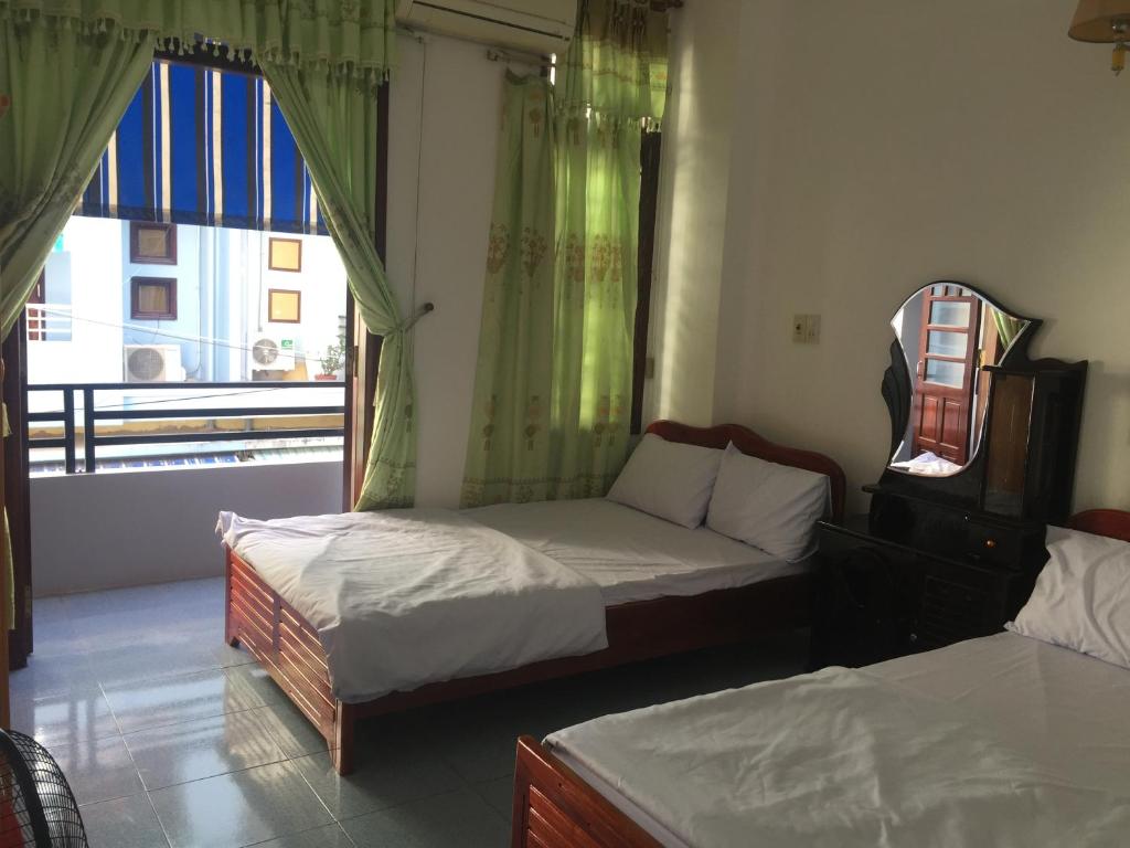 a bedroom with two beds and a window at Homestay Minh Nguyên in Hue