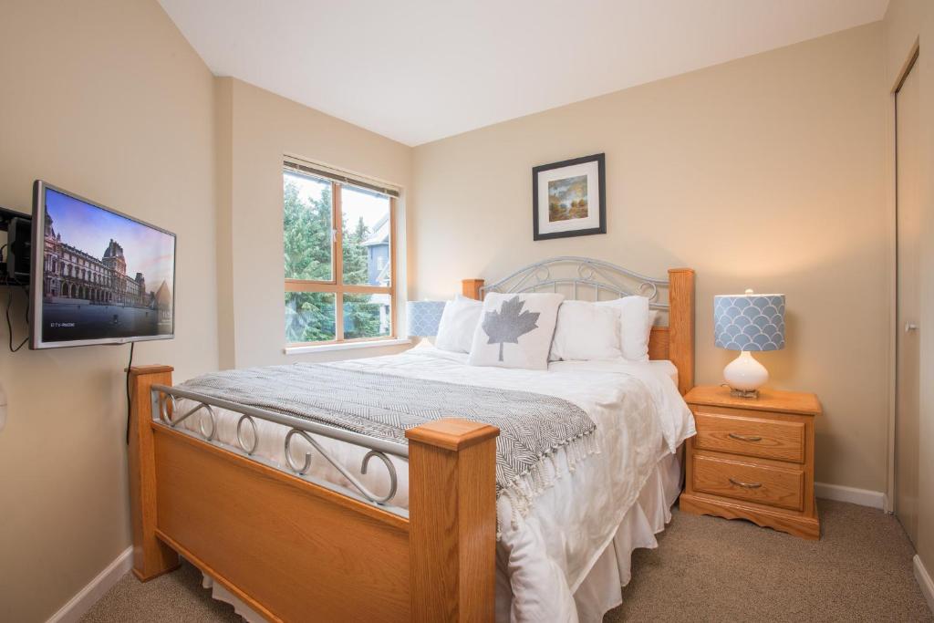 een slaapkamer met een groot bed en een raam bij R & R Retreat Luxury Condo in Whistler