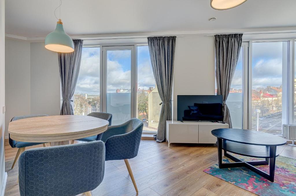 a living room with a table and chairs and a television at City View Apartment 57 in Vilnius