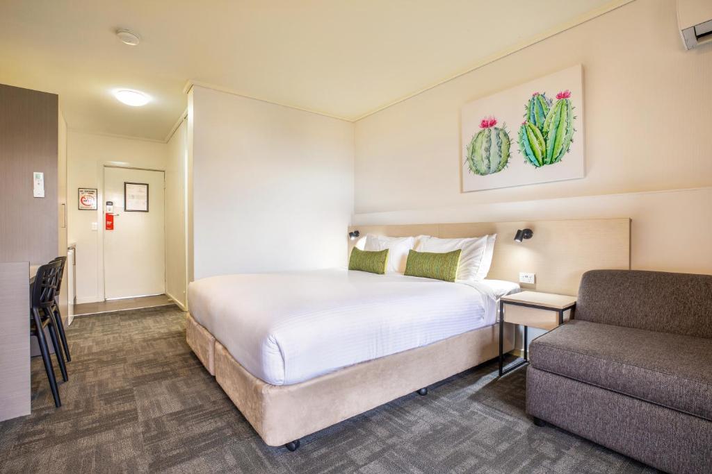 ein Hotelzimmer mit einem Bett und einem Sofa in der Unterkunft Nightcap at Shoppingtown Hotel in Doncaster