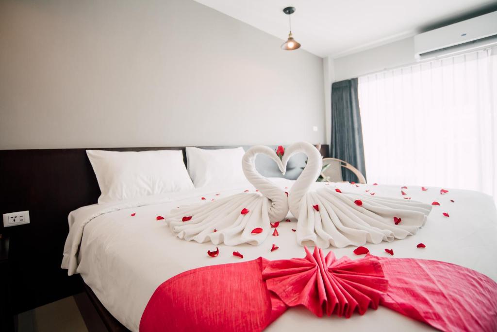 a bedroom with a bed with two white wings and hearts at Harvest House in Ao Nang Beach