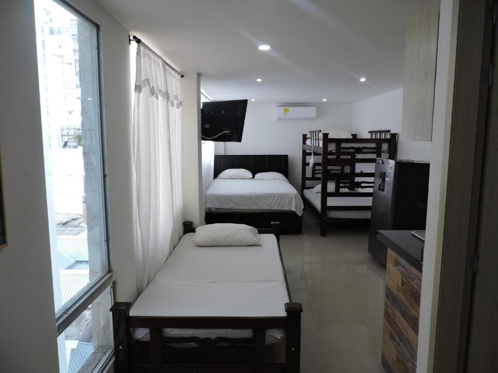 サンタ・マルタにあるApartahotel Dorado Rodaderoのベッドが2つと窓がある小さな部屋