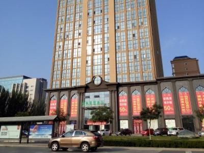 une voiture garée devant un grand bâtiment dans l'établissement GreenTree Alliance Ningxia Hui Autonomous Region Yinchuan South Bus Station Hotel, à Yinchuan