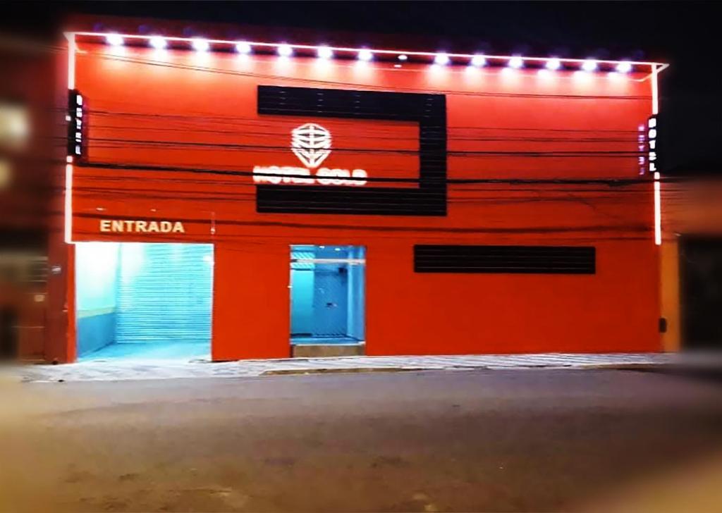 an orange building with a blue door and lights on it at Hotel Gold in Sao Paulo