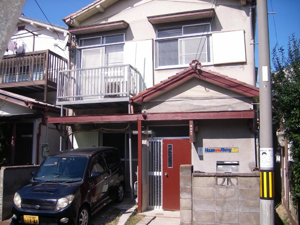 a black car parked in front of a house at House of the Rising Sun in Takatuki