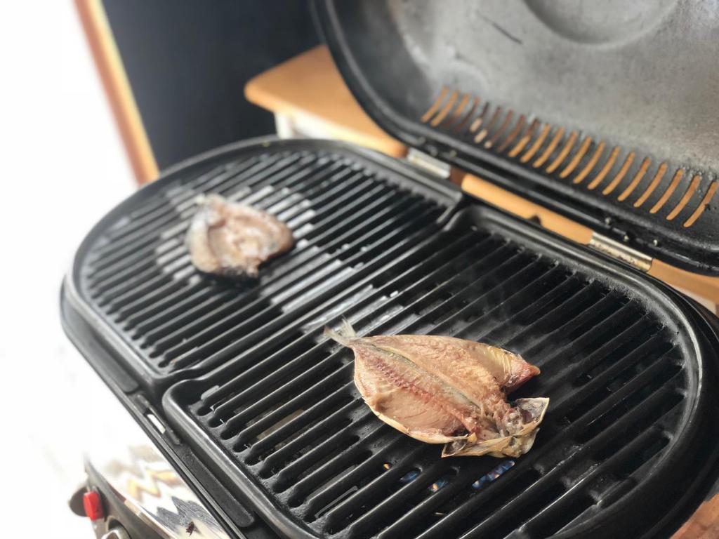 two pieces of meat cooking on a grill at Guest House MARUYA in Atami