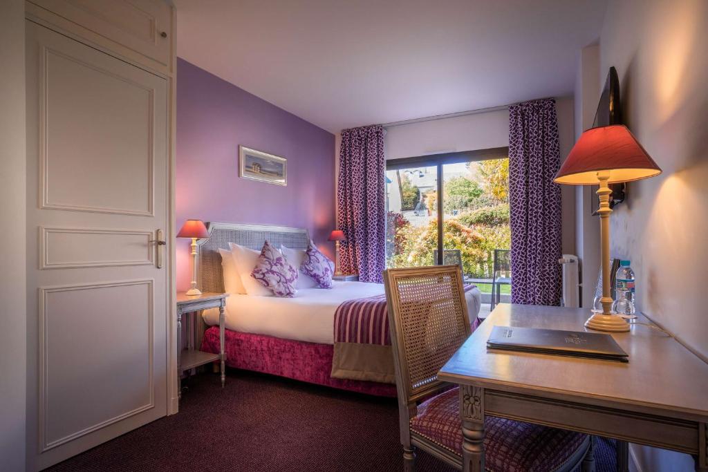 um quarto com uma cama, uma secretária e uma janela em Best Western Plus Hostellerie Du Vallon em Trouville-sur-Mer