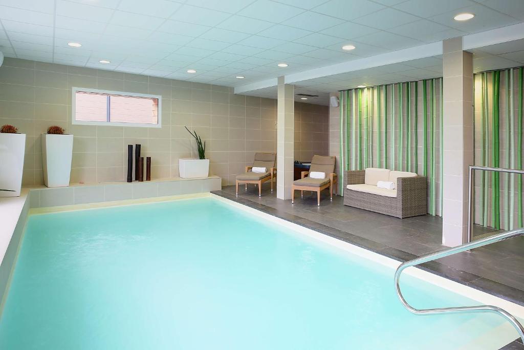a swimming pool in a room with a waiting room at Best Western Plus Les Terrasses de Bréhat in Ploubazlanec