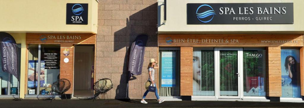 a woman walking in front of a store at Best Western Les Bains Hotel et SPA in Perros-Guirec