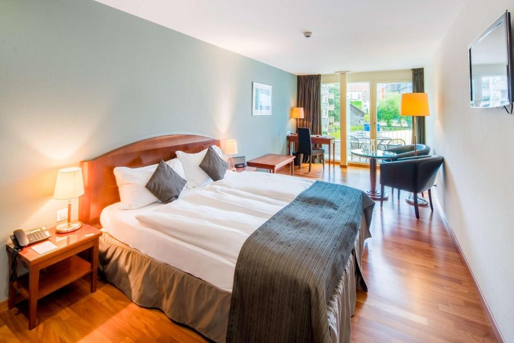 Postel nebo postele na pokoji v ubytování Hôtel Rallye & Entrées aux Bains de la Gruyère