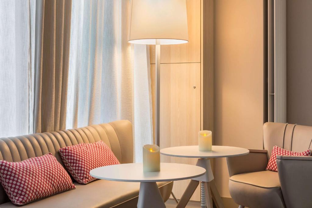 a room with two tables and a couch and a lamp at Best Western Les Bains Hotel et SPA in Perros-Guirec