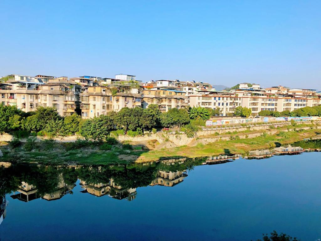 a reflection of buildings in a body of water at Lakeside Inn in Guilin
