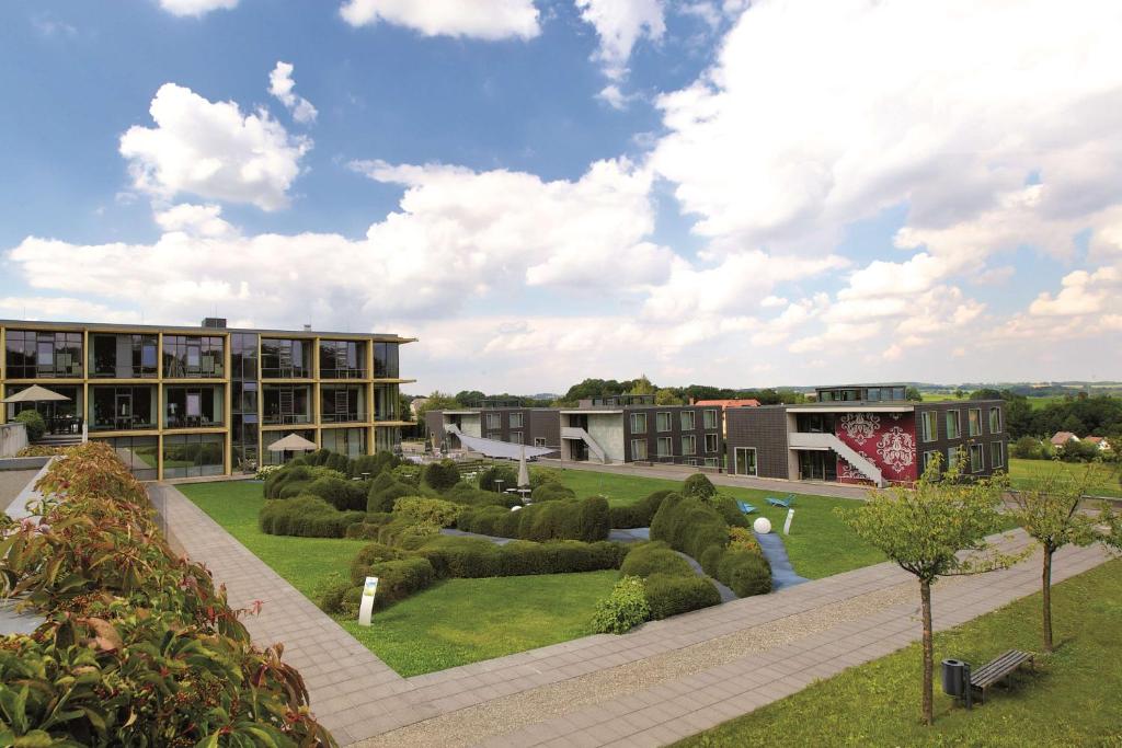 un edificio con giardino con cespugli e alberi di rugs Hotel am Schlosspark Lichtenwalde a Lichtenwalde