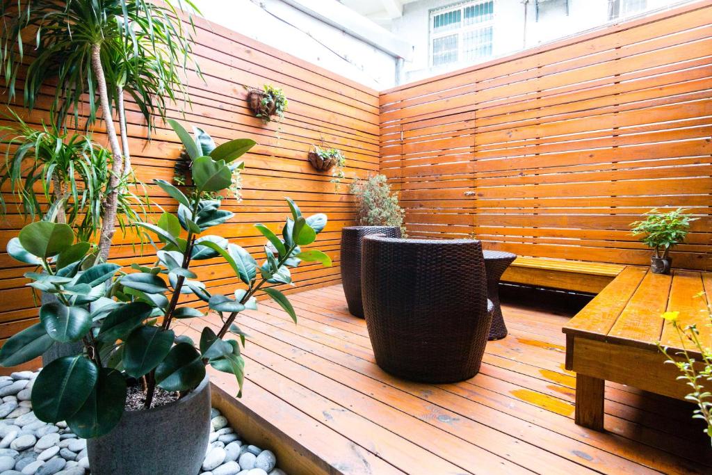 a patio with several potted plants and a wooden fence at 321 Apartment B&amp;B in Hualien City