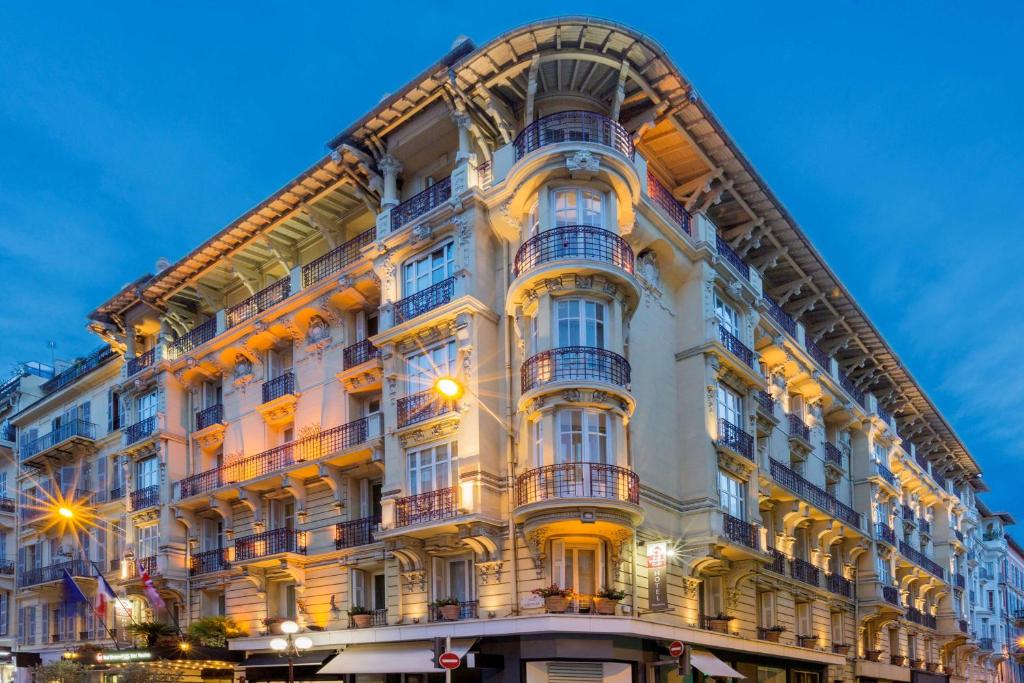 a large white building with balconies on a street at Best Western Plus Hôtel Massena Nice in Nice