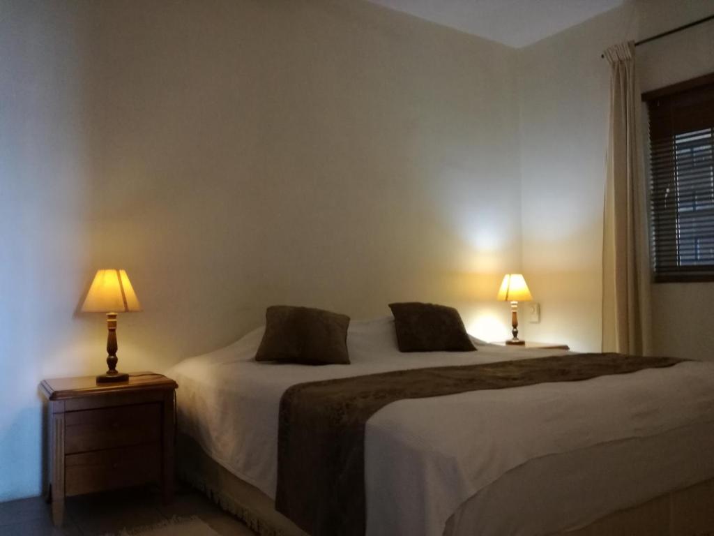 2 camas en un dormitorio con 2 lámparas en las mesas en Trendzone Apartments, en Grand Baie