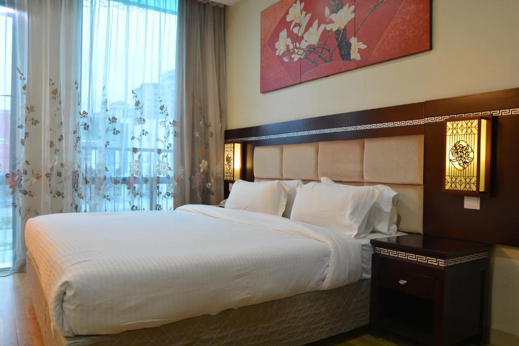 a bedroom with a large bed and a large window at De Residence Hotel in Ipoh