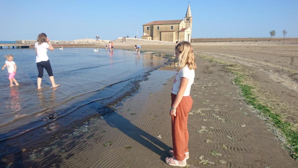Una mujer y un niño de pie en la playa en casa olmo, en Caorle