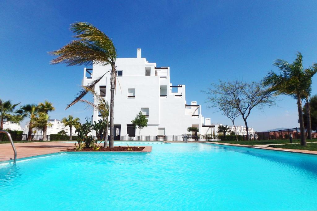 een gebouw met een zwembad voor een gebouw bij Alhama Golf Penthouses P02 in El Romero